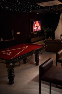ein Billardtisch in einem Raum mit einem Fernseher in der Unterkunft Presidential Suite In Gold Crest Residency-DHA Phase 4 Lahore in Lahore + 57 Fotos