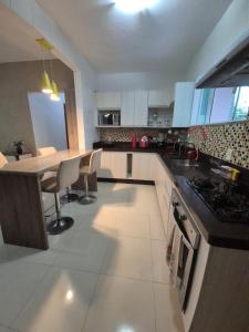 een keuken met een tafel en een fornuis bovenste oven bij Elis Praia e Aconchego in Iguaba Grande +30 foto's