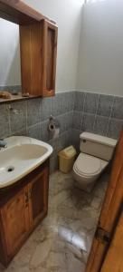 een badkamer met een wit toilet en een wastafel bij Urubamba in San Antonio