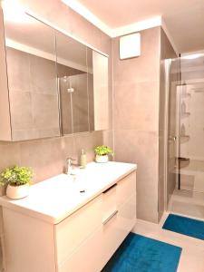 a bathroom with a white sink and a shower at SPA & SOUL Residence Neusiedl am See in Neusiedl am See