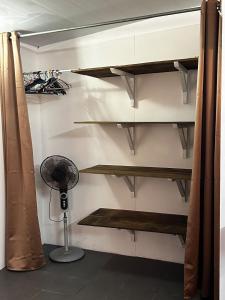 Camera con scaffali in legno e ventilatore. di M&M moanatea lodge a Rangiroa Altre 6 foto