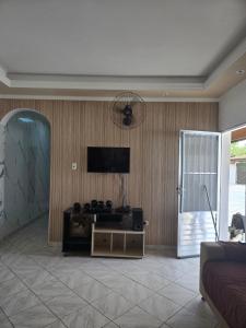 a living room with a flat screen tv on a wall at Casa grande e confortável em Ilha Comprida in Ilha Comprida