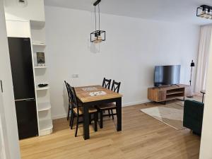 una sala da pranzo con tavolo, sedie e TV di Apartament Dobra Nocka 2 a Przeworsk