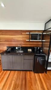 eine Küche mit Spüle und Mikrowelle in der Unterkunft Cabanas do Platô in Praia Grande