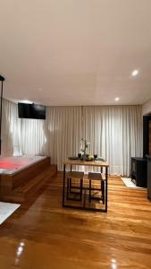 ein Zimmer mit einem Bett und einem Tisch darin in der Unterkunft Cabanas do Platô in Praia Grande