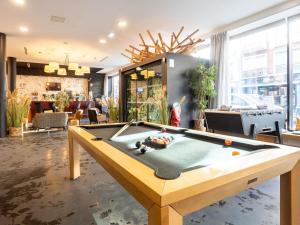 una mesa de billar en una sala con bar en ibis Styles Calais Centre, en Calais