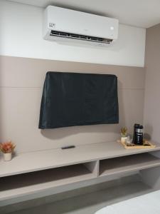 een flatscreen-tv die aan de muur hangt bij Studio Beach Class Summer em Porto de Galinhas PE in Porto De Galinhas