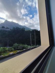 a view of a mountain from a window at Narciso's House in São Vicente