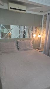 ein Schlafzimmer mit einem großen weißen Bett mit zwei Kissen in der Unterkunft Casa completa a 10min da praia de BC in Balneário Camboriú