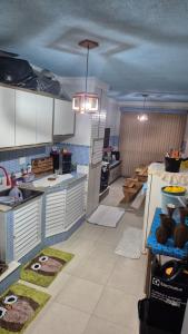 eine große Küche mit weißen Schränken und grünen Böden in der Unterkunft Casa completa a 10min da praia de BC in Balneário Camboriú