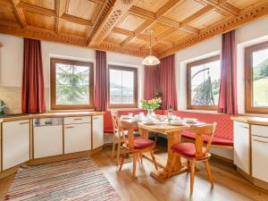 a kitchen with a table and chairs and windows at Almruhe Alpbach in Alpbach