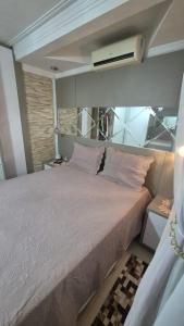 ein Schlafzimmer mit einem großen Bett mit einer weißen Bettdecke in der Unterkunft Casa completa a 10min da praia de BC in Balneário Camboriú