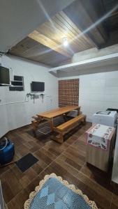 ein Wohnzimmer mit einem Holztisch und einem TV in der Unterkunft Casa completa a 10min da praia de BC in Balneário Camboriú