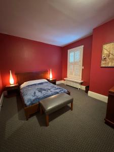 - une chambre avec des murs rouges, un lit et une fenêtre dans l'établissement 49 Hostel, à Toronto