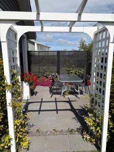 Una pérgola blanca con una mesa y sillas en un patio. en Studio on Patete, en Taupo 6 fotos más