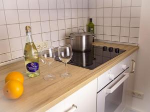 een aanrecht met 2 glazen en een fles wijn bij Romantic half-timbered house in Egestorf