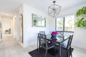ein Esszimmer mit Tisch und Stühlen und einem Spiegel in der Unterkunft Centrally Located Modern 2bdr Home w Fast WiFi & Parking in Miami