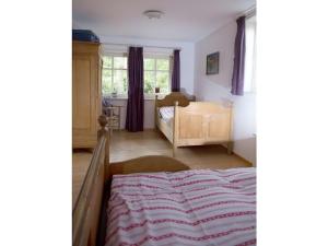 een kinderkamer met een bed en een raam bij Romantic half-timbered house in Egestorf