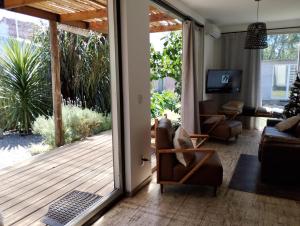a living room with a door open to a deck at La Pausa Container House in Manantiales