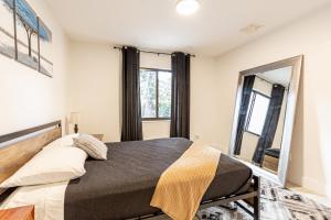 ein Schlafzimmer mit einem Bett und einem großen Spiegel in der Unterkunft Centrally Located Modern 2bdr Home w Fast WiFi & Parking in Miami