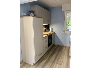 eine Küche mit weißen Schränken und einem weißen Kühlschrank in der Unterkunft 1 - Anett Pollok in Neuruppin