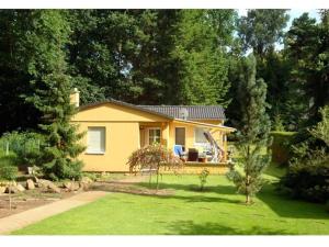 ein kleines gelbes Haus in der Mitte eines Gartens in der Unterkunft 1 - Anett Pollok in Neuruppin