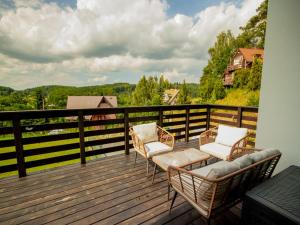 a deck with two chairs and a couch on it at A comfortable house in Kashubia for 5 people in Gołubie