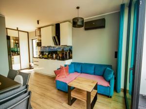 a living room with a blue couch and a table at A comfortable house in Kashubia for 5 people in Gołubie