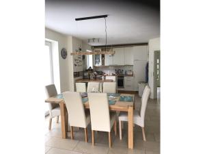 een keuken en eetkamer met een tafel en stoelen bij House 4seasons Scharbeutz in Scharbeutz