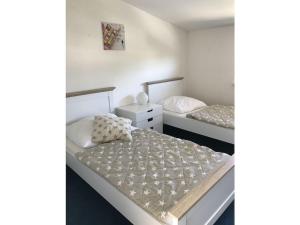 twee bedden in een kleine kamer met witte muren bij House 4seasons Scharbeutz in Scharbeutz