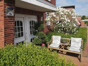 un banc avec deux oreillers assis à l'extérieur d'une maison dans l'établissement North Beach Pearl 2, à Norderney