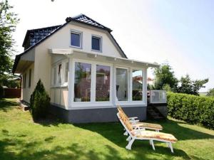 ein winziges Haus mit einer Veranda und zwei Stühlen in der Unterkunft Holiday home in Buschvitz with barbecue in Buschvitz