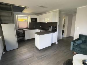 eine Küche mit weißen Schränken und einer blauen Couch in der Unterkunft Holiday home in Buschvitz with barbecue in Buschvitz + 9 Fotos
