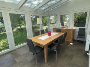 ein Esszimmer mit Tisch und Stühlen und Fenstern in der Unterkunft Holiday home in Buschvitz with barbecue in Buschvitz