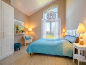 ein Schlafzimmer mit einem blauen Bett und einem Fenster in der Unterkunft Seepark - Holiday Home - Rügen in Vaschvitz