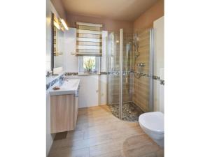 ein Badezimmer mit Dusche, Toilette und Waschbecken in der Unterkunft Seepark - Holiday Home - Rügen in Vaschvitz + 15 Fotos