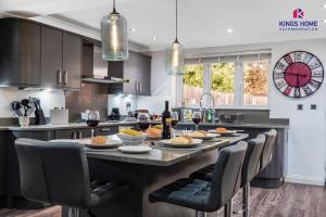 een keuken met een grote tafel met eten en wijnglazen bij 4 BR 6 Beds 3 Bath PS4, Pool Table Parking x4 Close to Legoland & Windsor in Maidenhead +21 foto's