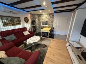 ein Wohnzimmer mit einem roten Sofa und einem Tisch in der Unterkunft Dahlke with fireplace and sauna in Kleinweidelbach