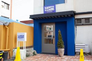 a building with a blue door and a sign on it at Slowcruise in Gongju