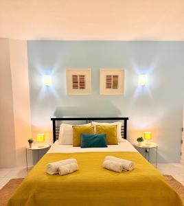 a bedroom with a large yellow bed with two pillows at Casa Flor de Sal Apartment in Carvoeiro