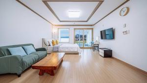 a living room with a couch and a table at Geoje Haneul Ari Pension in Geoje