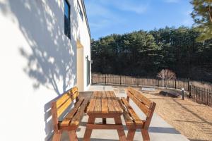 a wooden bench sitting on the side of a building at Gangneung Solol Pension in Gangneung