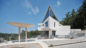 a large white building with a pointed roof at Buan Intaglio Pool Villa in Buan