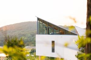 a white house with glass windows on top of it at Buan Intaglio Pool Villa in Buan