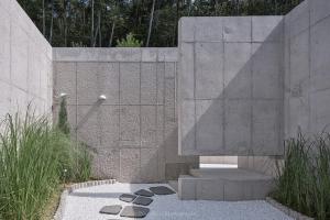 a bathroom with a shower in a concrete wall at Buan Intaglio Pool Villa in Buan +20 photos