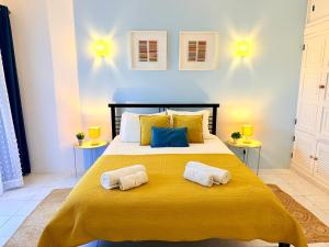 a bedroom with a large bed with two towels on it at Casa Flor de Sal Apartment in Carvoeiro