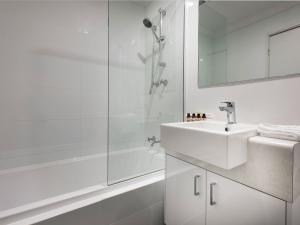 a white bathroom with a sink and a shower at Be. Fremantle in Fremantle +43 photos