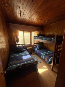a room with two bunk beds in a cabin at Natural Lodge Maitencillo in Maitencillo