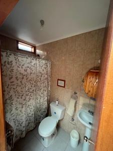 a bathroom with a toilet and a sink at Natural Lodge Maitencillo in Maitencillo