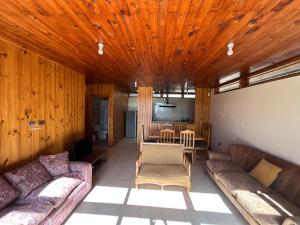 a living room with two couches and a table at Natural Lodge Maitencillo in Maitencillo +10 photos